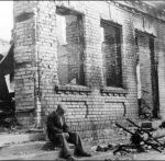 Местный житель на ступеньках разрушенного дома в центре Гродно. 1941 год